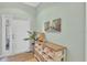 Welcoming entryway with a white door, stylish console table, woven baskets and an inviting beach themed art piece at 9312 Coachman Dr, Venice, FL 34293