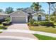 Charming home with well-manicured landscaping, a brick driveway, and a welcoming front entrance at 9312 Coachman Dr, Venice, FL 34293