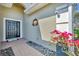 Inviting front entrance with a black door, brick walkway, and decorative stone accents with vibrant bougainvillea at 9312 Coachman Dr, Venice, FL 34293
