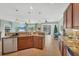 Open-concept kitchen featuring granite countertops, dark wood cabinetry, and seamless flow into dining/living at 9312 Coachman Dr, Venice, FL 34293