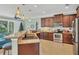 Open-concept kitchen featuring stainless steel appliances, granite countertops, and pendant lighting at 9312 Coachman Dr, Venice, FL 34293
