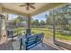 Covered lanai with outdoor seating and views of the green backyard and surrounding trees at 9312 Coachman Dr, Venice, FL 34293