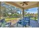 Screened patio with brick flooring, ceiling fan, and comfortable seating, overlooking the picturesque backyard at 9312 Coachman Dr, Venice, FL 34293