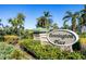 Community entrance sign for Pennington Place, surrounded by lush landscaping and mature palm trees at 9312 Coachman Dr, Venice, FL 34293