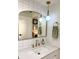 Bright bathroom featuring updated vanity with gold hardware, white tile, and modern mirror and light fixture at 937 Nettuno Dr, Venice, FL 34285