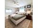 Chic bedroom featuring gallery wall, ceiling fan and quilted green bedding with patterned rug at 937 Nettuno Dr, Venice, FL 34285