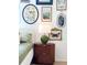 Closeup of bedroom decor with gallery wall, green bedding, and oval wood nightstand at 937 Nettuno Dr, Venice, FL 34285