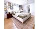 Stylish bedroom featuring gallery wall, ceiling fan and quilted green bedding with patterned rug at 937 Nettuno Dr, Venice, FL 34285