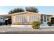 Charming manufactured home featuring a covered carport, white trim, and manicured landscaping at 937 Nettuno Dr, Venice, FL 34285