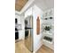 Well-lit kitchen showcasing stainless steel refrigerator and open shelving with decorative glassware at 937 Nettuno Dr, Venice, FL 34285