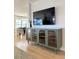Stylish living room featuring a modern entertainment center and view into the dining area at 937 Nettuno Dr, Venice, FL 34285