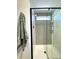Modern shower with herringbone tile, glass door, brushed gold fixtures, and tiled shampoo niche at 937 Nettuno Dr, Venice, FL 34285