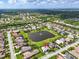 Stunning aerial view of a serene neighborhood featuring a picturesque lake with a fountain and well-maintained lawns at 988 145Th Street Ne Cir, Bradenton, FL 34212