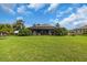 Expansive backyard with lush lawn and tropical landscaping, featuring a screened in lanai at 988 145Th Street Ne Cir, Bradenton, FL 34212