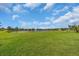 Open green backyard and pond with beautiful Florida landscaping at 988 145Th Street Ne Cir, Bradenton, FL 34212