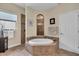 Bathroom featuring a soaking tub with beautiful tile surround and walk-in shower at 988 145Th Street Ne Cir, Bradenton, FL 34212