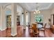 Charming dining area with wood floors, chandelier lighting, and a view of the front entrance at 988 145Th Street Ne Cir, Bradenton, FL 34212