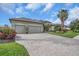 Wide brick paver driveway leading to a spacious two-car garage, with lush landscaping at 988 145Th Street Ne Cir, Bradenton, FL 34212