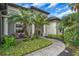 Inviting front entrance with columns, a brick walkway, and lush, manicured landscaping at 988 145Th Street Ne Cir, Bradenton, FL 34212