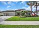 Charming single-story home with well-maintained landscaping, palm trees, and a paver driveway at 988 145Th Street Ne Cir, Bradenton, FL 34212