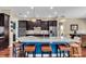 Beautiful kitchen with marble countertop island, stainless steel appliances, brown cabinets, and barstool seating at 988 145Th Street Ne Cir, Bradenton, FL 34212