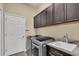 Convenient laundry room with modern washer, dryer, ample cabinetry, and a utility sink at 988 145Th Street Ne Cir, Bradenton, FL 34212