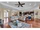 Expansive living room with hardwood floors flowing into the open kitchen with a large leather sectional sofa at 988 145Th Street Ne Cir, Bradenton, FL 34212
