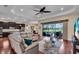 Open-concept living room with hardwood floors, patio access, and adjacent modern kitchen at 988 145Th Street Ne Cir, Bradenton, FL 34212