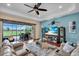 Comfortable living room with a ceiling fan, outdoor view, and stylish furnishings at 988 145Th Street Ne Cir, Bradenton, FL 34212