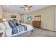 Spacious main bedroom featuring neutral walls, ceiling fan, TV, and natural wood dresser with mirror at 988 145Th Street Ne Cir, Bradenton, FL 34212