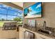 Outdoor kitchen area with grill, bar sink, granite countertops, and mini-refrigerator at 988 145Th Street Ne Cir, Bradenton, FL 34212
