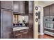 Chic wet bar featuring dark cabinetry, a marble countertop and mirrored backsplash at 988 145Th Street Ne Cir, Bradenton, FL 34212