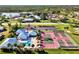 Aerial shot featuring community amenities: pool, tennis courts, and clubhouse set amongst mature trees at 3008 Sail Pointe Cir # 2C, Venice, FL 34293