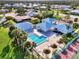 Aerial view of community pool, clubhouse, and tropical landscaping in a residential neighborhood at 3008 Sail Pointe Cir # 2C, Venice, FL 34293