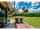 Relaxing brick patio with two lounge chairs, a small table, and views of the manicured lawn at 3008 Sail Pointe Cir # 2C, Venice, FL 34293