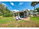 Expansive backyard featuring a patio with lounge chairs, outdoor seating, and mature landscaping at 3008 Sail Pointe Cir # 2C, Venice, FL 34293