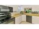 Bright kitchen featuring modern appliances, white cabinets, and functional tile flooring for easy maintenance at 3008 Sail Pointe Cir # 2C, Venice, FL 34293