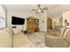 Comfortable living room with ceiling fan, sofa, entertainment center and a neutral area rug at 3008 Sail Pointe Cir # 2C, Venice, FL 34293