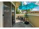 Cozy outdoor patio featuring stylish stone flooring, seating for four, and a vibrant blue umbrella providing ample shade at 3008 Sail Pointe Cir # 2C, Venice, FL 34293