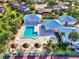 Aerial view of community pool with sun loungers, umbrellas and a nearby spa at 3008 Sail Pointe Cir # 2C, Venice, FL 34293