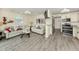 Cozy living room area with kitchen offers modern appliances, beach themed decor and grey wood floors at 1001 Inlet Cir # 269, Venice, FL 34285