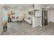 Open living room with bar area, tile floors, stainless refrigerator, coastal decor and sliding glass doors to the outside at 1001 Inlet Cir # 269, Venice, FL 34285