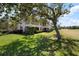 Scenic backyard view of the home with a well-maintained lawn and mature shade trees at 1007 Gondola Park Dr # 1007, Venice, FL 34292