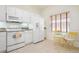 Cozy kitchen with white appliances, tile flooring, and a small table with seating near window at 1007 Gondola Park Dr # 1007, Venice, FL 34292