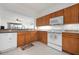 This kitchen features wooden cabinets, white appliances, and an open layout at 1007 Gondola Park Dr # 1007, Venice, FL 34292