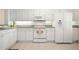 Bright white kitchen with tile floors, modern appliances, and ample cabinet space at 1007 Gondola Park Dr # 1007, Venice, FL 34292