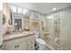 Well-lit bathroom with a granite vanity, a glass-enclosed shower, and modern fixtures at 1100 Tarpon Center Dr # 104, Venice, FL 34285