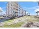 Multi-story condo building with balconies, beachfront access, and landscaping at 1100 Tarpon Center Dr # 104, Venice, FL 34285