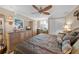 Inviting bedroom with ceiling fan, shutters, wooden dresser and view of the ocean at 1100 Tarpon Center Dr # 104, Venice, FL 34285