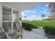 Comfortable patio seating with manicured lawn and ocean views at 1100 Tarpon Center Dr # 104, Venice, FL 34285